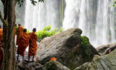 Group of young buddhist monks enjoying the view of Kulen Waterfall in Cambodia, Asia