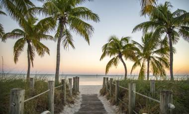 Key West Florida - Famous passage to the beach with palms, sunset and view on the ocean.