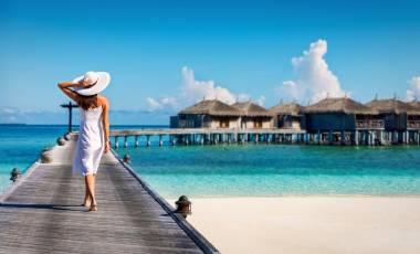 Asian couple enjoying romantic luxury lunch setting at tropical beach in Maldives