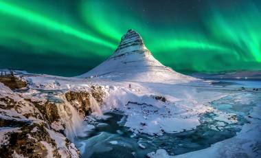 northern lights appear over Mount Kirkjufell in Iceland.