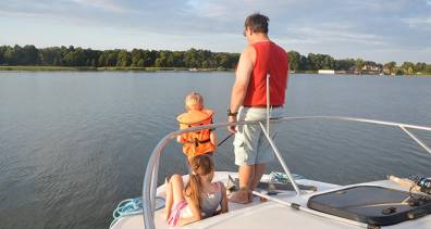 Mann und Kind beim Angeln auf einem Hausboot auf der Mecklenburgischen Seenplatte