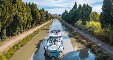 A canal boat cruises the scenic Canal du Midi along the Canal du Midi, offering a relaxing way to explore southern France.