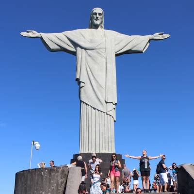 a man standing in front of Christ the Redeemer