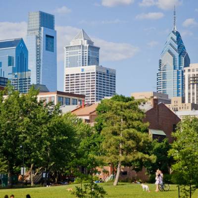 a group of people in a park with a city in the background