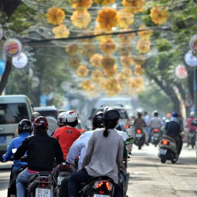 a man riding a motorcycle on a city street filled with lots of traffic