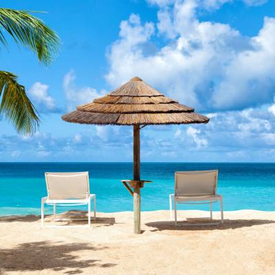 a couple of lawn chairs sitting on top of a beach
