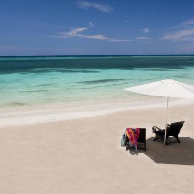a sandy beach next to a body of water