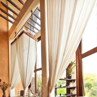 a chair sitting in front of a curtain