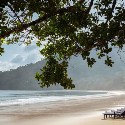 a sandy beach next to a body of water