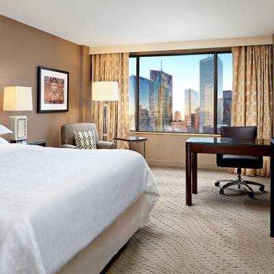a bedroom with a bed and desk in a hotel room