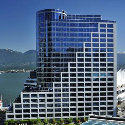 a large ship in a body of water with a city in the background