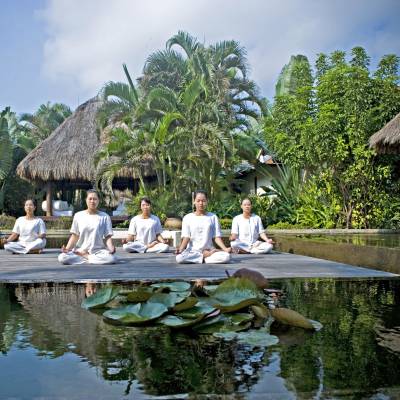 a group of people sitting around a pond