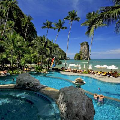 a group of palm trees next to a body of water