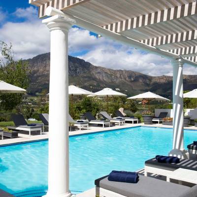 a group of lawn chairs sitting next to a pool of water