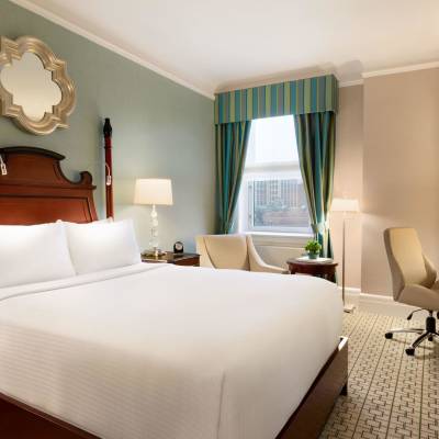 a bedroom with a bed and desk in a hotel room