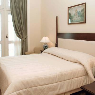 a bedroom with a bed and desk in a hotel room