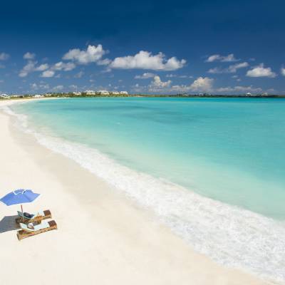 a sandy beach next to a body of water