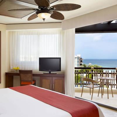 a hotel room with a bed and a chair in front of a window