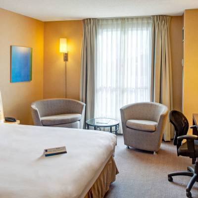a bedroom with a bed and desk in a hotel room
