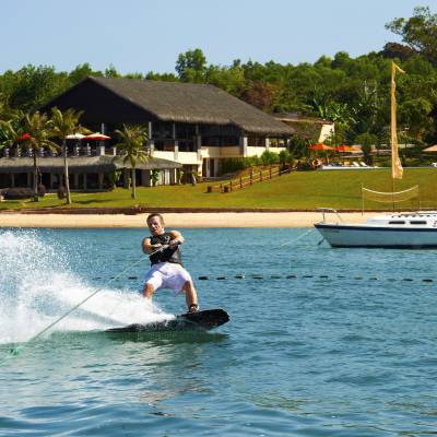 a man riding on the back of a boat in the water