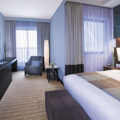 a bedroom with a bed and desk in a hotel room