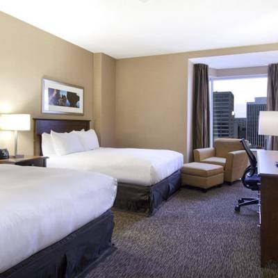 a bedroom with a bed and desk in a hotel room