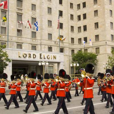 a group of people walking down the street with Rockefeller Center in the background