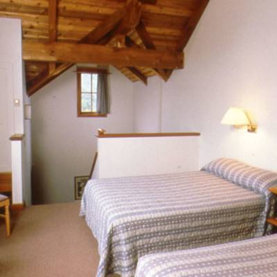 a bedroom with a bed and a chair in a room