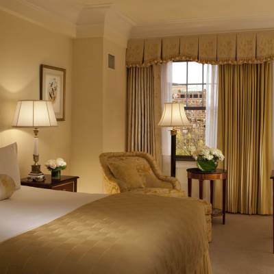 a bedroom with a bed and a chair in a room