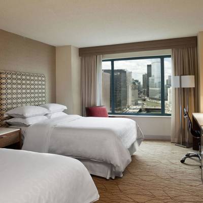 a bedroom with a bed and desk in a hotel room