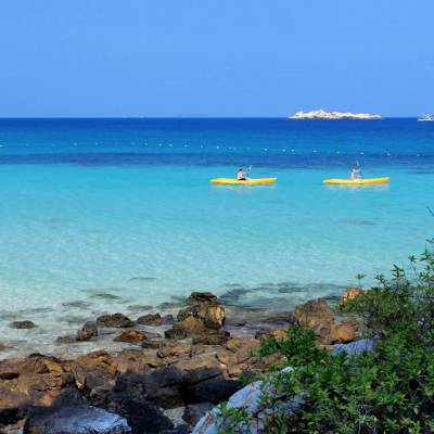 a blue frisbee sitting on top of a beach near a body of water