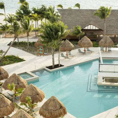 a group of palm trees with a building in the background