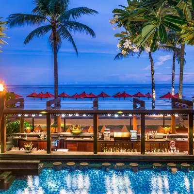 a group of palm trees next to a body of water