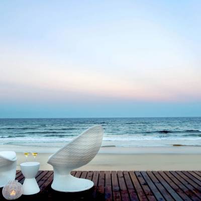 a chair sitting in front of a beach next to a body of water