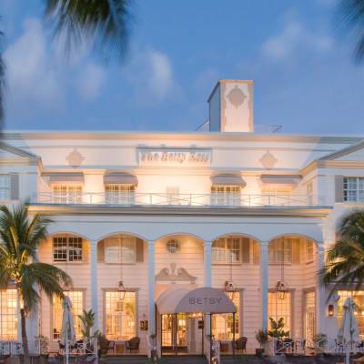 a group of palm trees with a building in the background