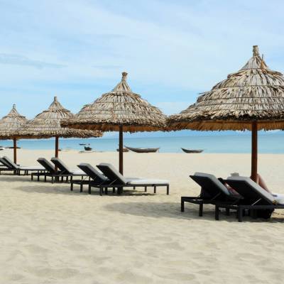 a row of wooden benches sitting on top of a sandy beach