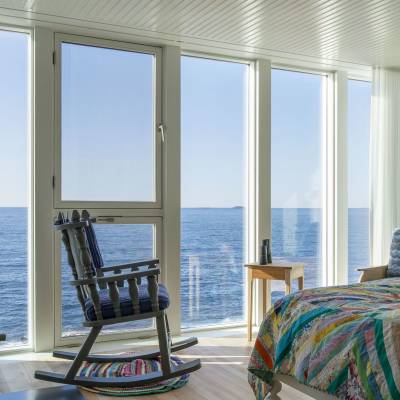 a bedroom with a bed and a chair in front of a window