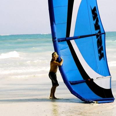 a person standing on a beach holding a surf board