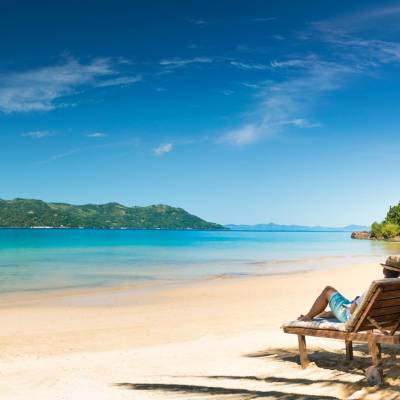 a chair sitting in front of a beach next to a body of water