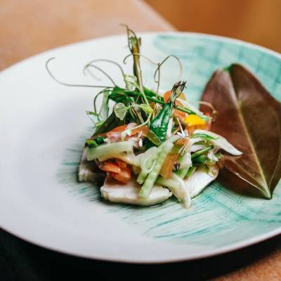 a white plate topped with a salad and a fork on a table