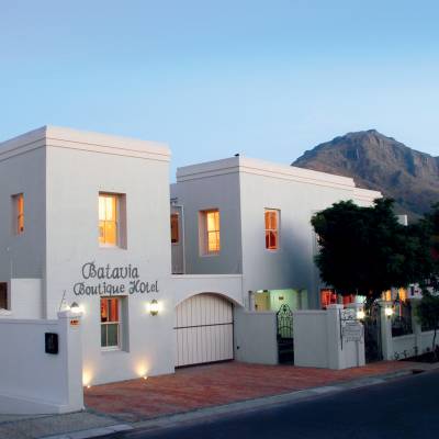 a large white building with a mountain in the background