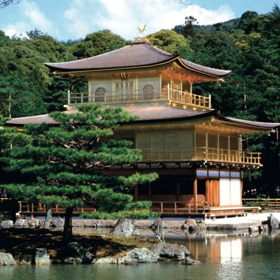a small house in a body of water with Kinkaku-ji in the background