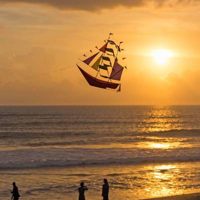 a group of people on a beach with a sunset in the background