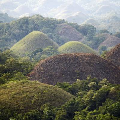 a view of a large mountain in the background with Chocolate Hills in the background