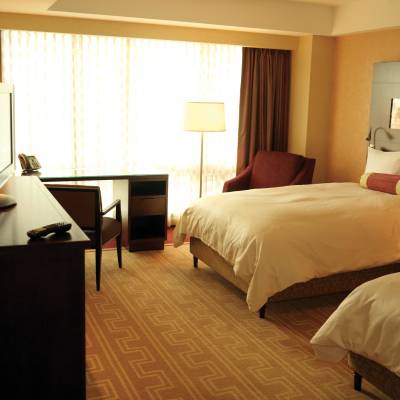 a bedroom with a bed and desk in a hotel room