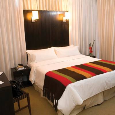 a bedroom with a bed and desk in a hotel room