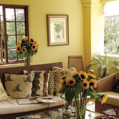 a living room filled with furniture and vase of flowers on a table
