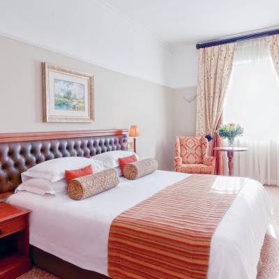 a bedroom with a bed and a chair in a room