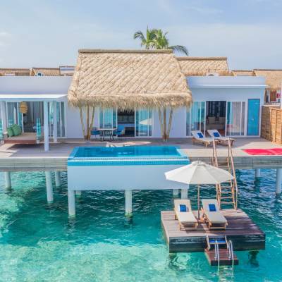 a group of lawn chairs sitting on top of a blue pool of water