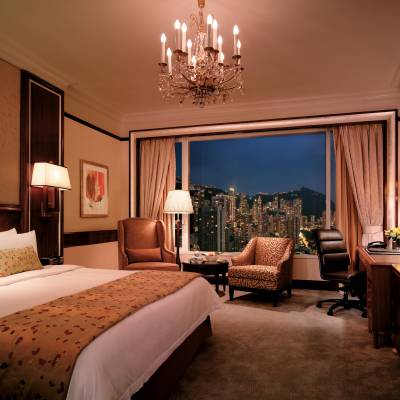 a bedroom with a bed and desk in a hotel room